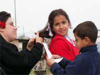 photo: young girl getting hair brushed; young boy in front